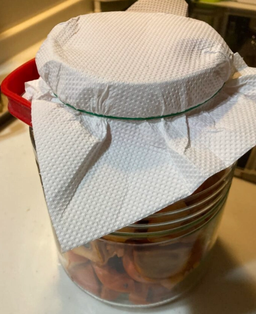 手作り柿酢の発酵用に容器をキッチンペーパーで密閉せず覆った様子
