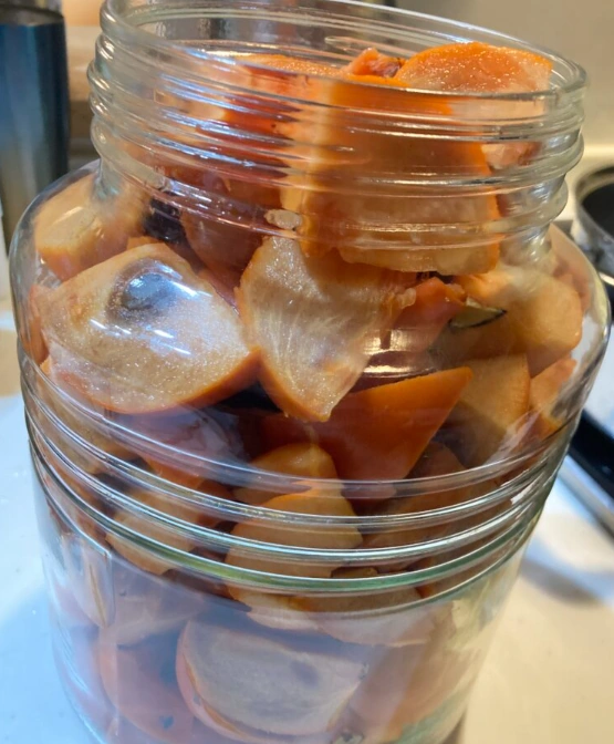 手作り柿酢用に刻んだ柿を発酵容器へ詰めた工程写真