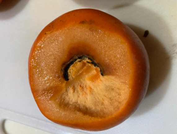 柿酢作りに使用する完熟した柿のヘタ部分の写真