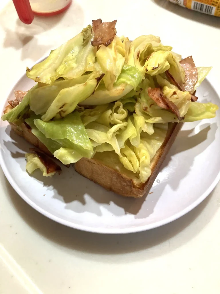 トーストした食パンの上に焼いたキャベツとベーコンをのせた様子