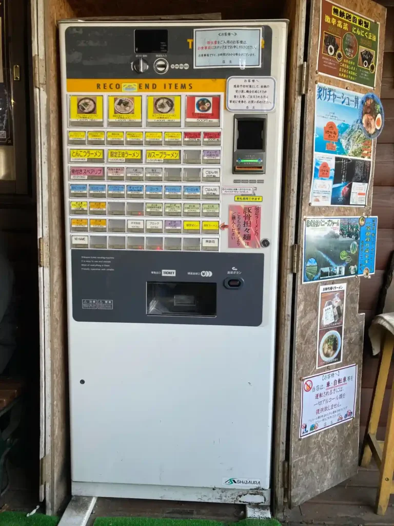 ラーメン店入口に設置された食券券売機の写真