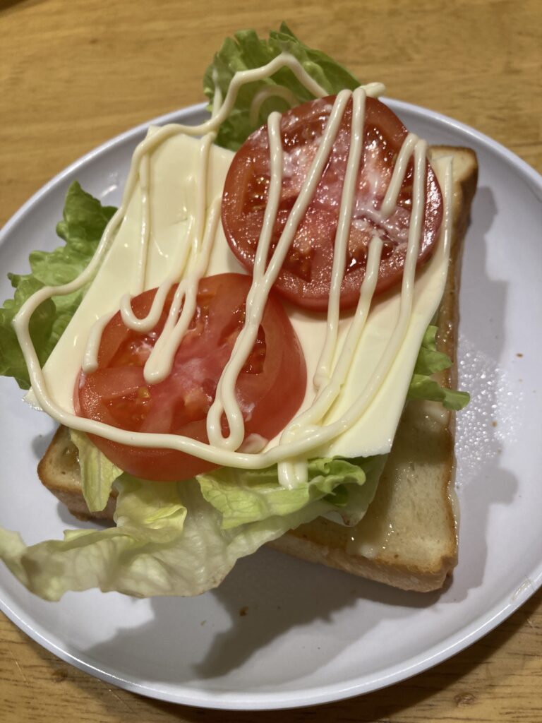 食パンにレタス、トマトをのせた写真