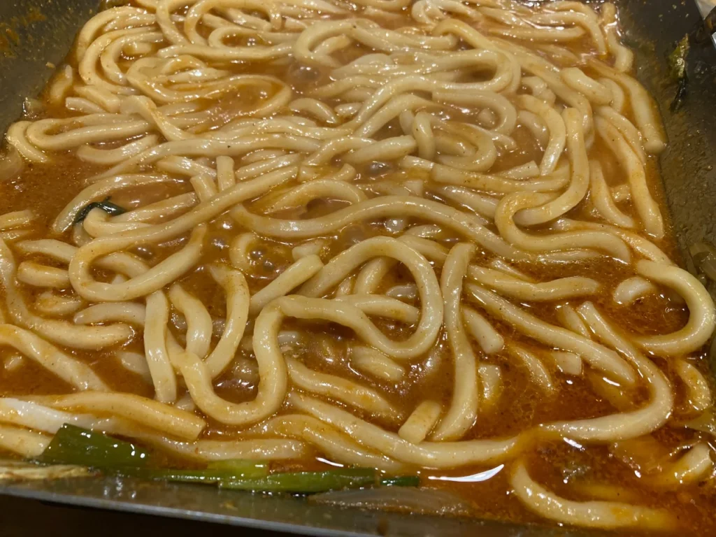 チリトリ鍋の締めに入れたうどん（旨味たっぷりのスープで煮込んだ様子）