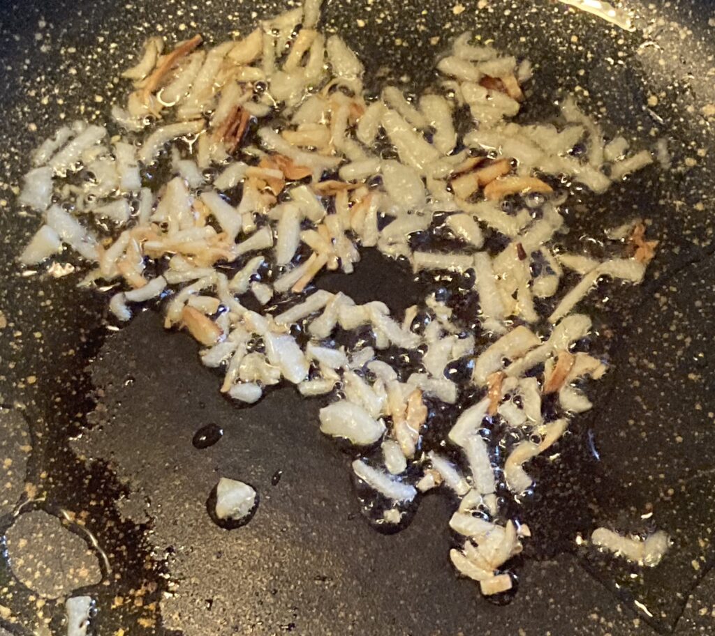 暗殺者のパスタでにんにくを炒めている様子