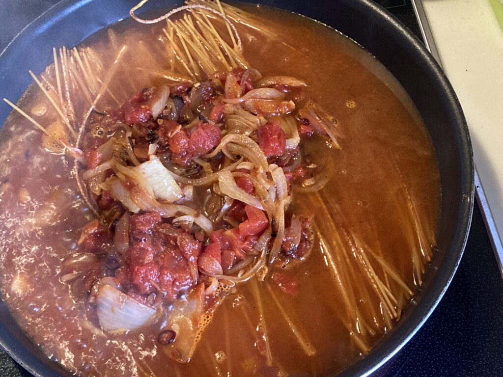 暗殺者のパスタでパスタとトマトソースを合わせて煮込む工程