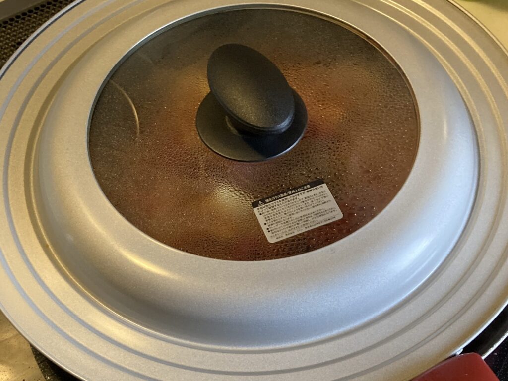 暗殺者のパスタをフライパンに蓋をして蒸す工程