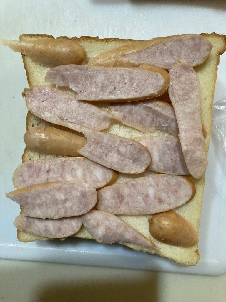 食パンの上にスライスしたウインナーを並べたウィンナートースト