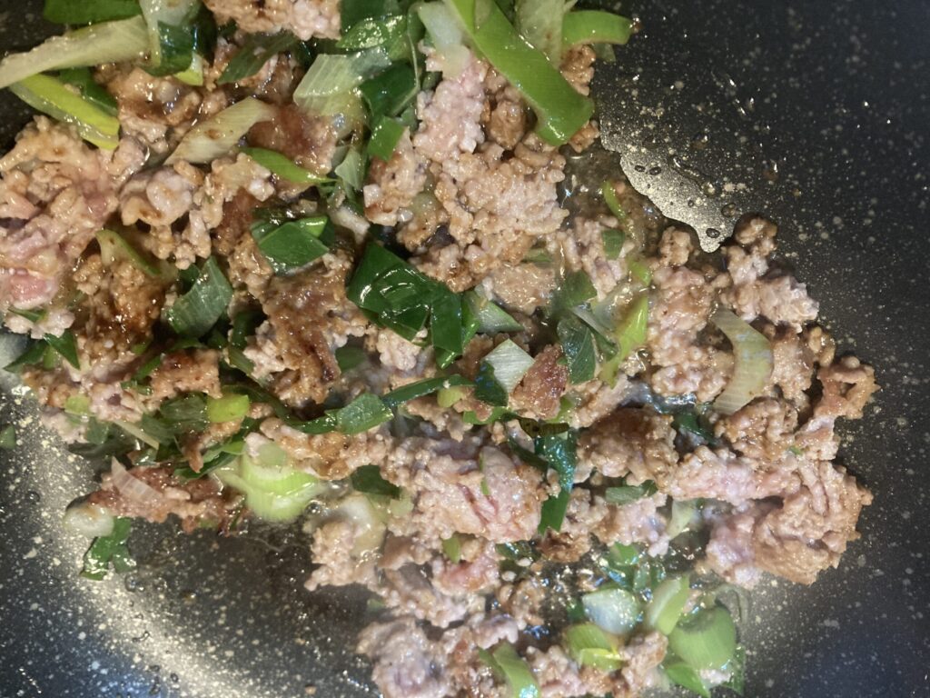 豚ひき肉にネギ・しょうが・にんにくを加えて炒めている麻婆豆腐の調理工程
