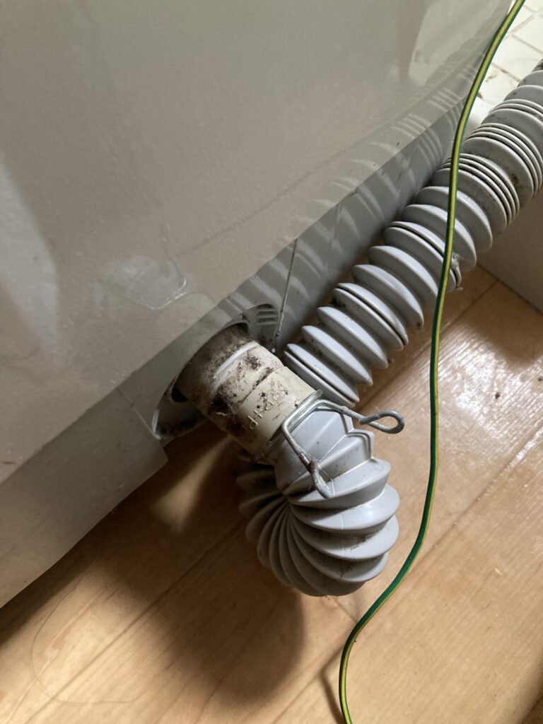洗濯機の排水ホースバンドを緩めてホースを抜く作業