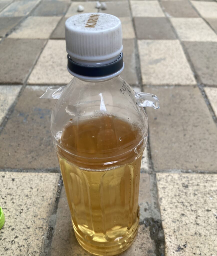水で10倍に薄めた木酢液を入れたペットボトルをフタして置いている様子の写真