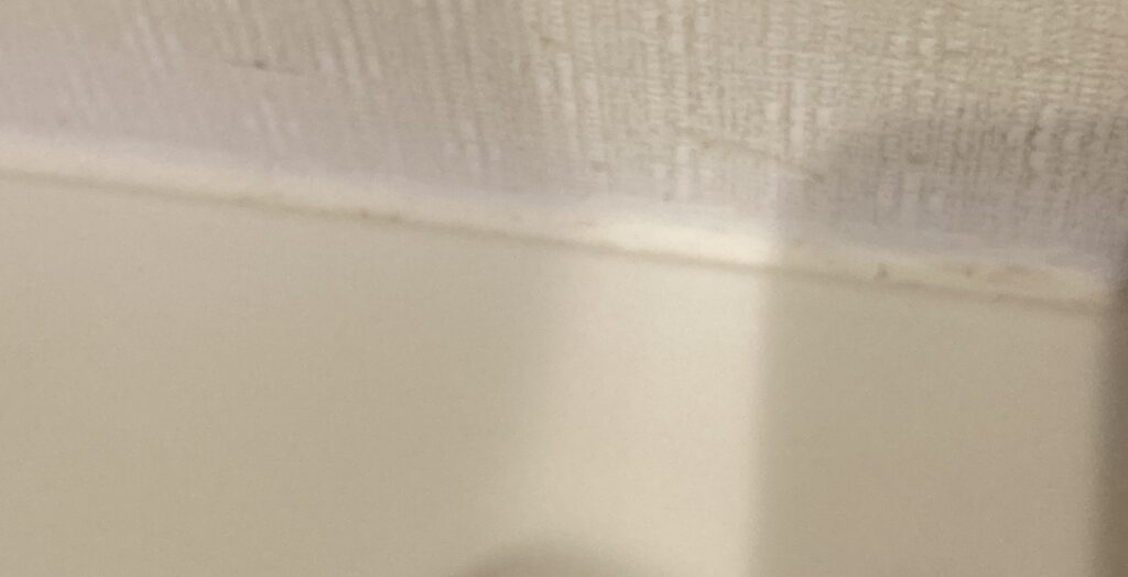 かびとりいっぱつ使用後の洗面台と壁の接触部分のカビが除去された状態