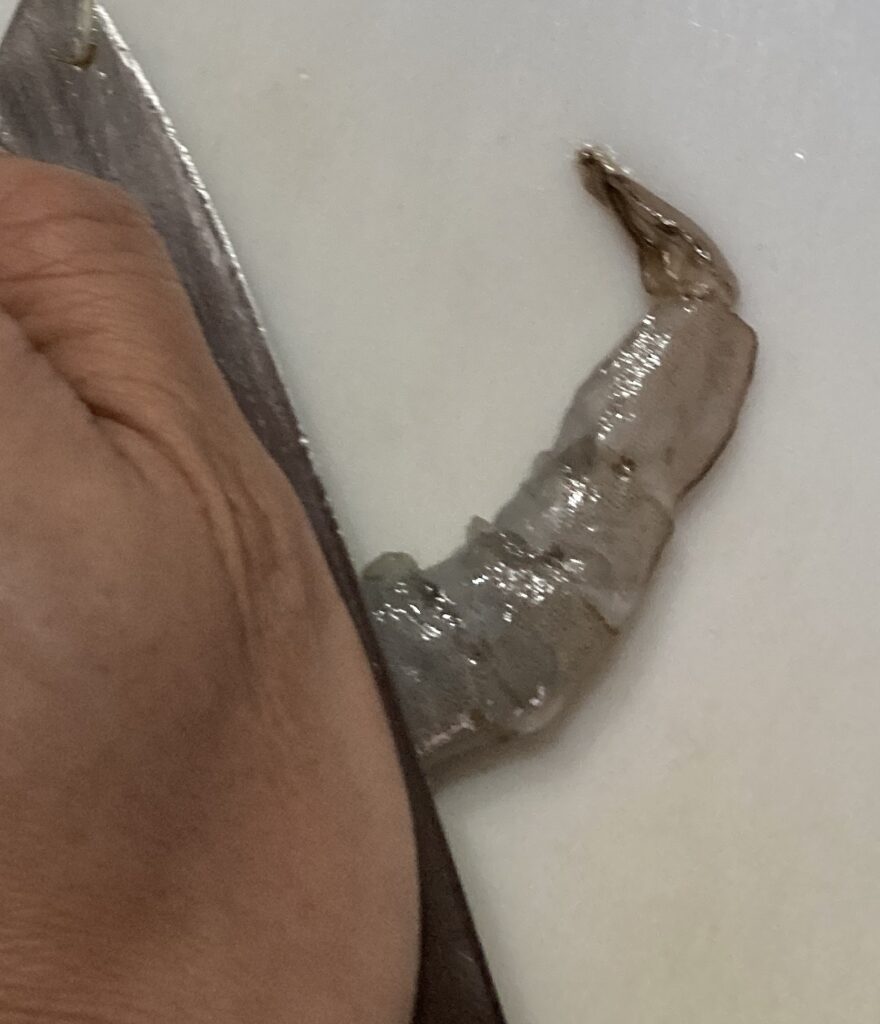 包丁の腹でむきエビを押しつぶして食感を出す下処理