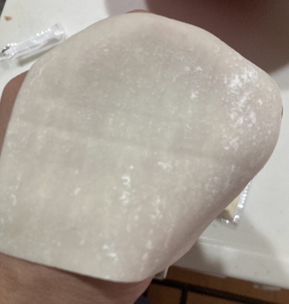 シュウマイの皮を手のくぼみにのせて包む準備をする