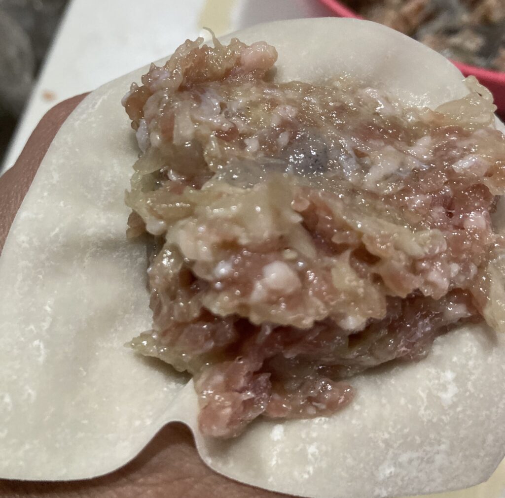 シュウマイの皮に肉だねをたっぷりのせる工程