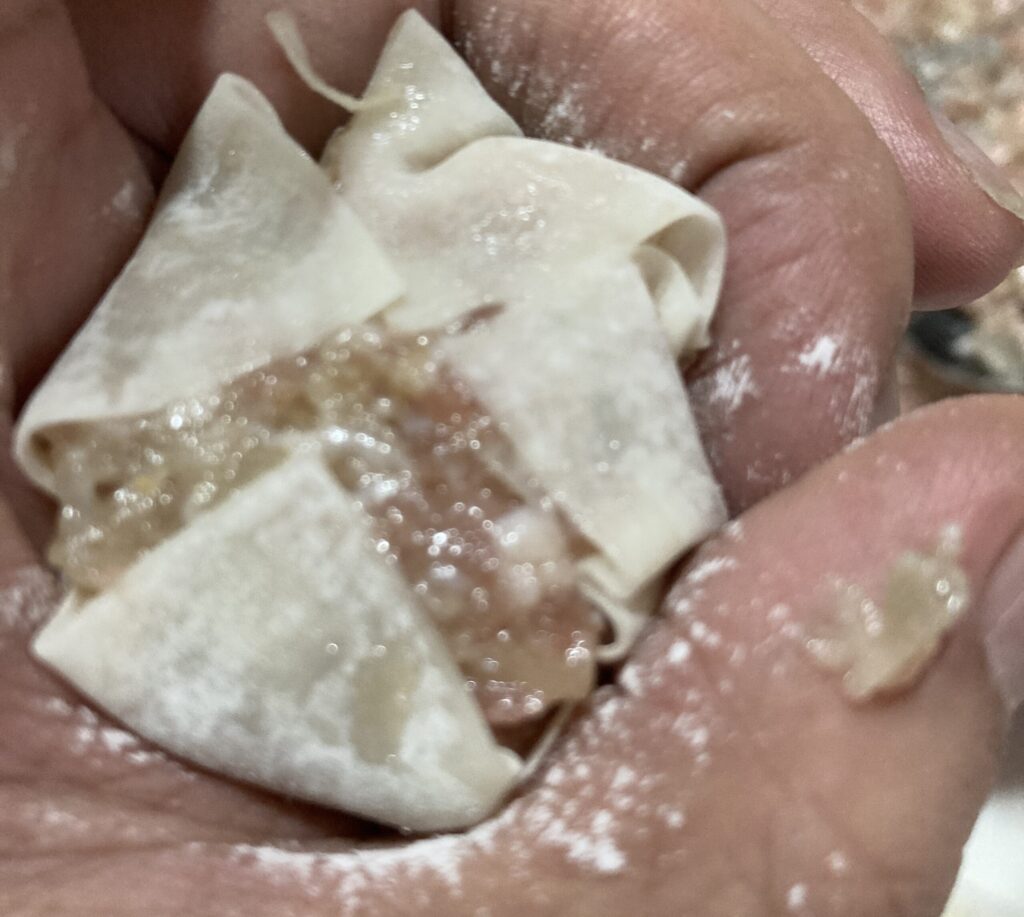 シュウマイの余った皮をスプーンで折りたたんで形を整える