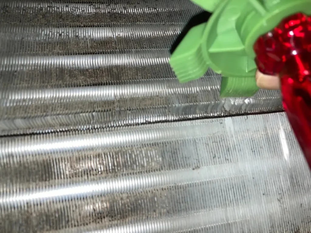 フィンストレイテナーでエアコンの曲がったアルミフィンを修正している様子