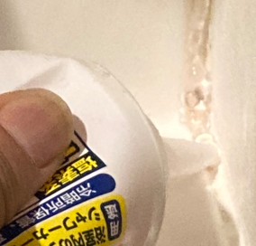 かびとりいっぱつを洗面台の隙間のカビに塗布している作業風景