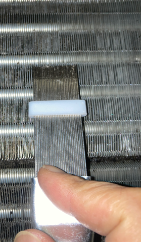 フィンストレートナーでエアコンのアルミフィンを整えている作業