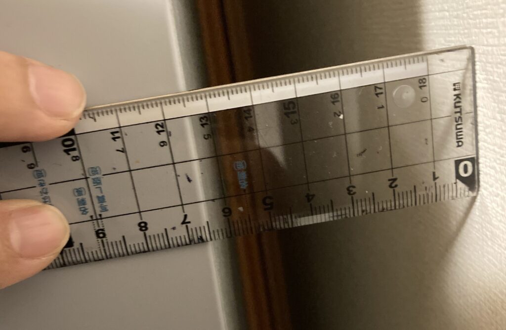 冷凍庫と壁の隙間を定規で測定した写真（約6.5cmの設置スペースに調整）