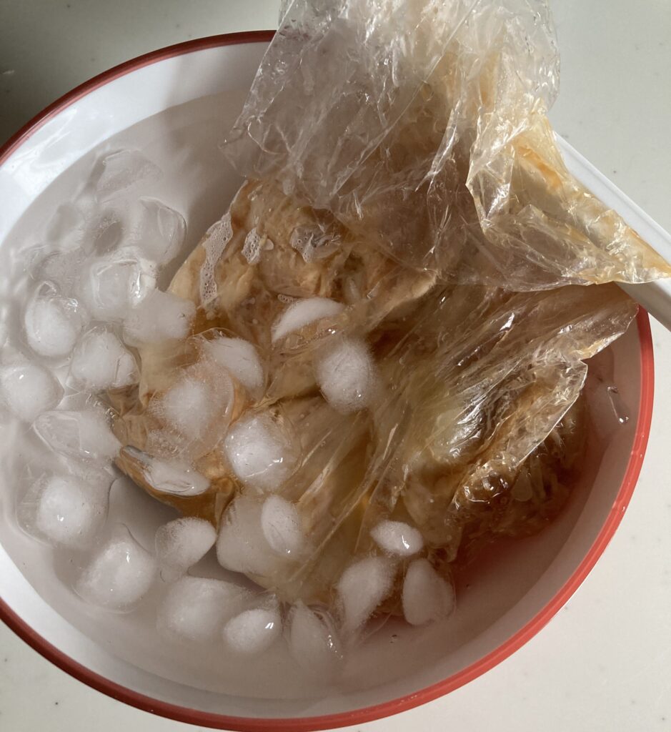 低温調理後の鶏むね肉を氷水で冷やして余熱を止める様子(サラダチキン仕上げ)