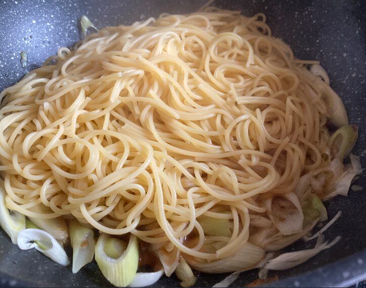 ゆで上がったパスタをフライパンの野菜と一緒に加えた状態
