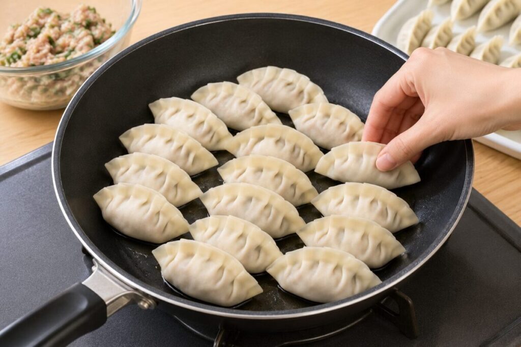 餃子をフライパンに並べている